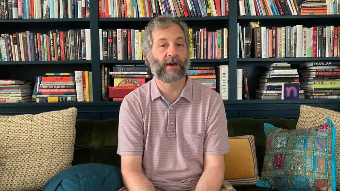 A person sitting on a couch in front of a bookshelf, discussing reasons some never forgive celebrities.